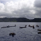 Dugout canoes lining up to get a closer look at the ship.
