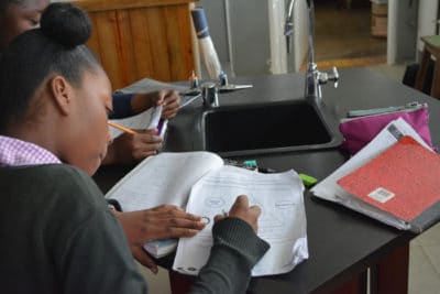 St. Hilda's student taking notes in English, not Patois.